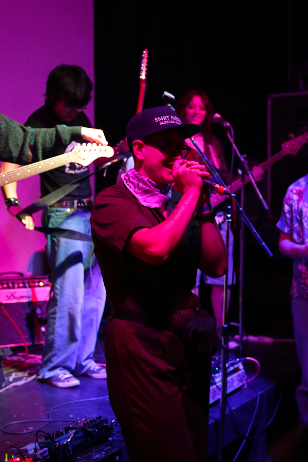 A Venue Co-op community member performing on stage with a microphone